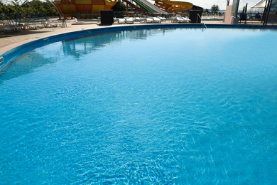 Photo of Outdoor swimming pool with clear water on sunny day. Summer vacation