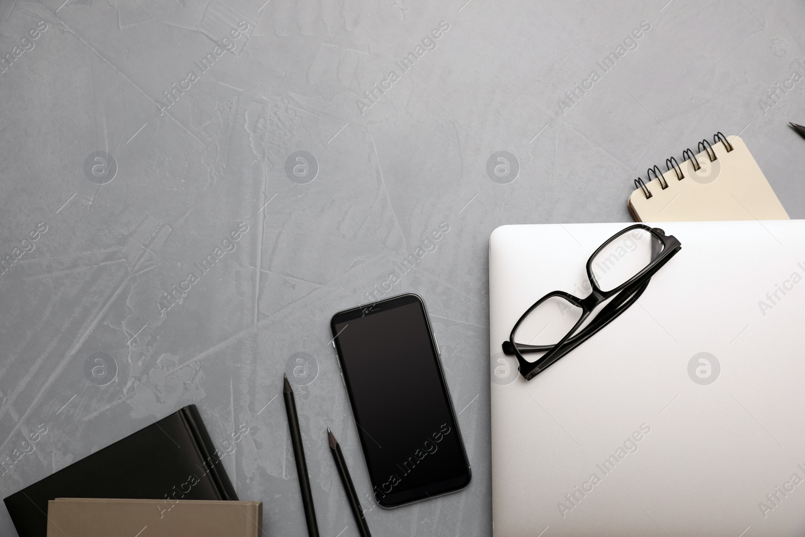 Photo of Laptop, smartphone and stationery on grey table, flat lay. Space for text