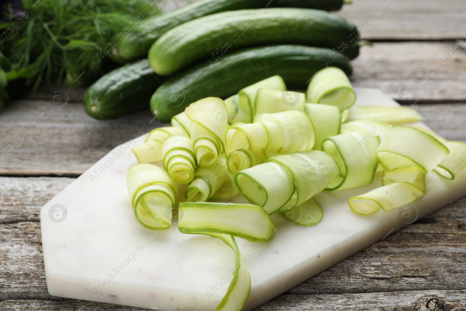 Photo of Slices of fresh ripe cucumbers on wooden table, closeup