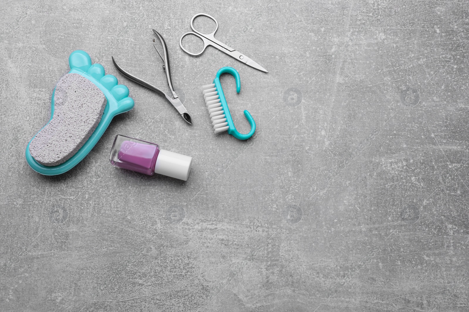 Photo of Set of pedicure tools on light gray table, flat lay. Space for text