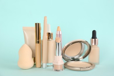 Photo of Foundation makeup products on turquoise background. Decorative cosmetics