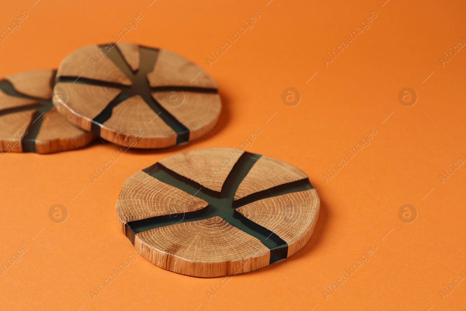 Photo of Many stylish cup coasters on orange background