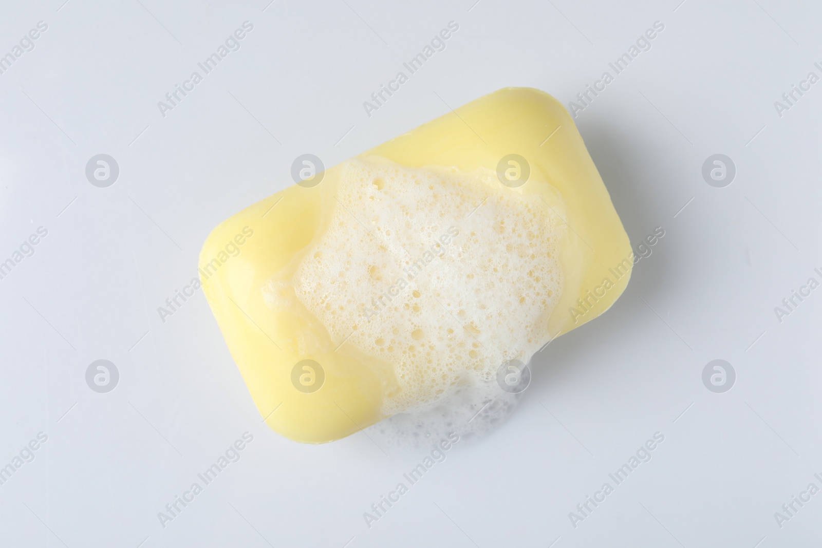 Photo of Soap with fluffy foam on white background, top view