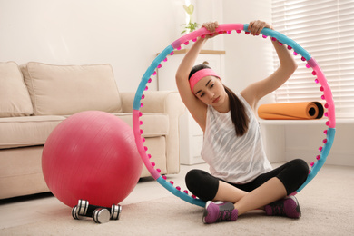 Photo of Lazy young woman with sport equipment at home