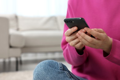 Photo of Woman sending message via smartphone indoors, closeup. Space for text