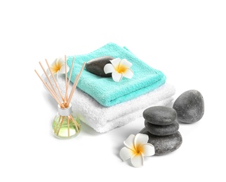 Beautiful composition with towels and spa stones on white background