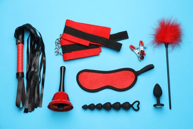 Photo of Sex toys and accessories on light blue background, flat lay
