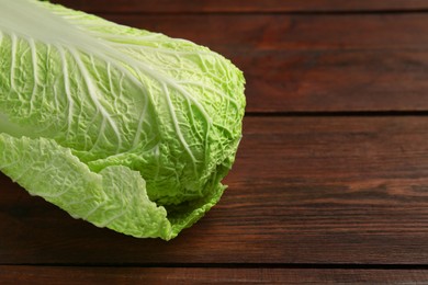 Photo of Fresh ripe Chinese cabbage on wooden table, closeup. Space for text