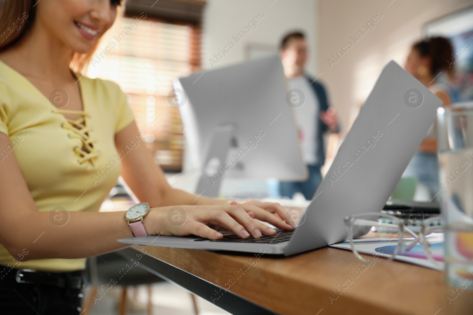 Photo of Female designer working with laptop at table, closeup