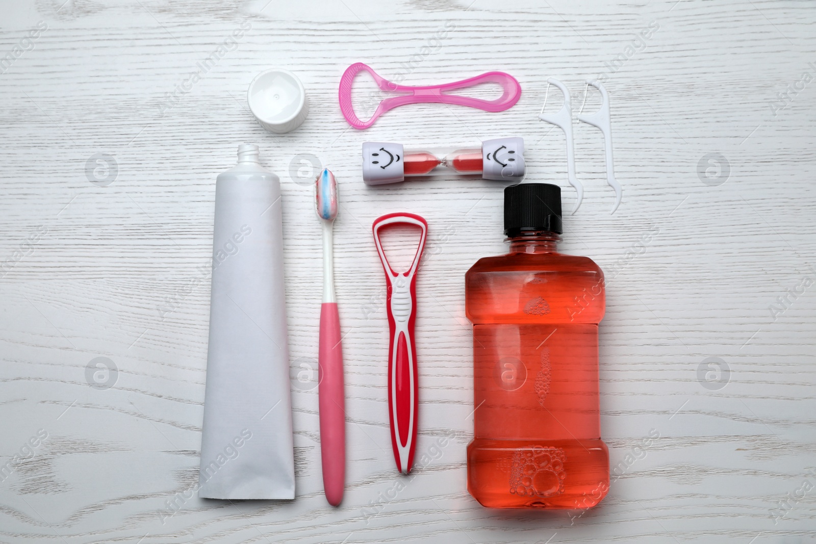 Photo of Flat lay composition with tongue cleaners and teeth care products on white wooden table