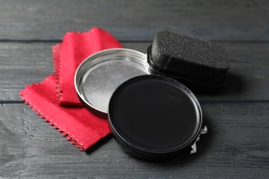 Shoe care accessories on black wooden background, closeup