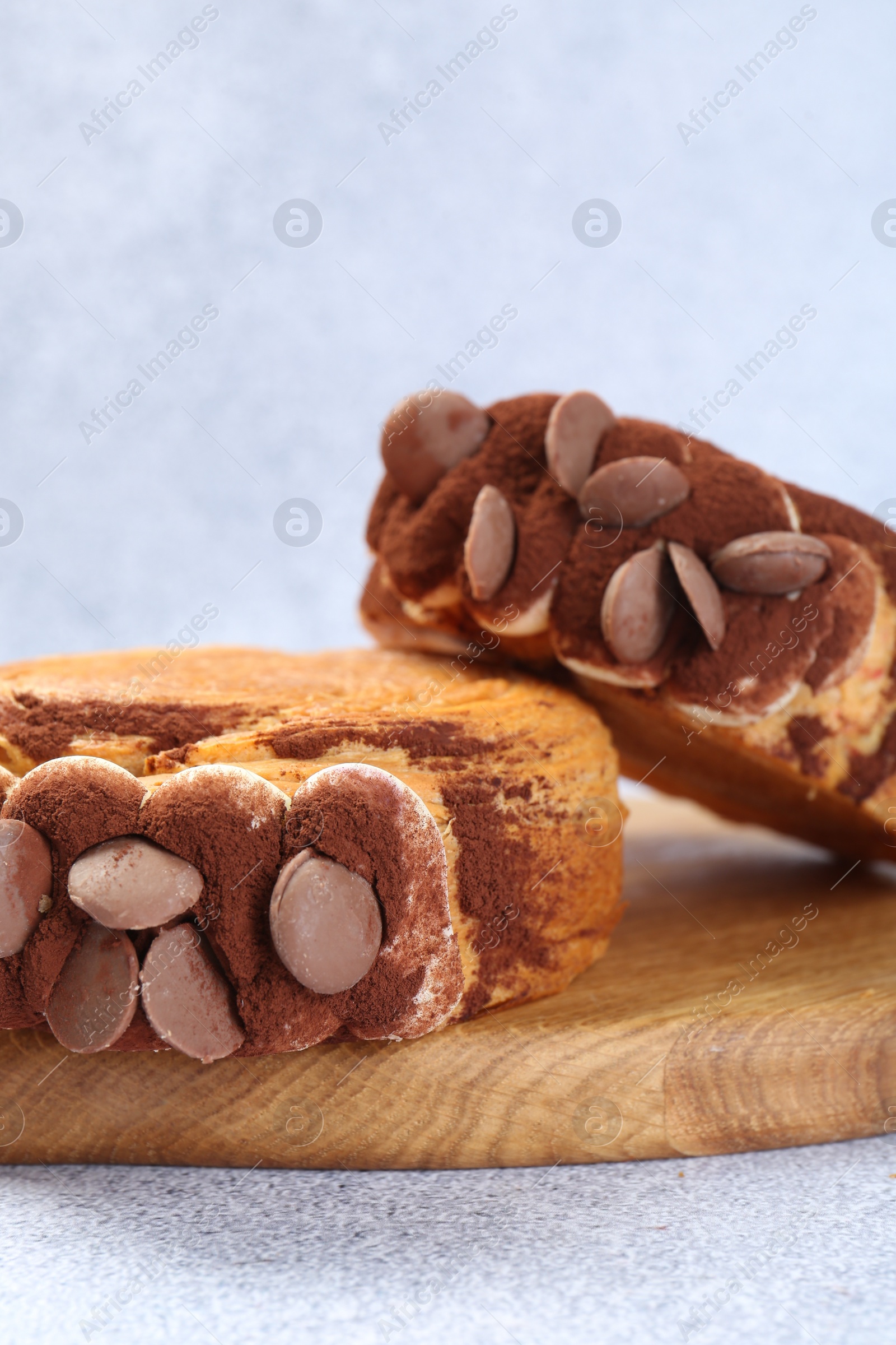 Photo of Supreme croissants with chocolate chips and cream on grey table, closeup. Tasty puff pastry