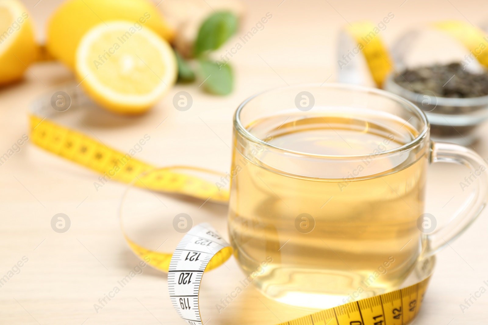 Photo of Diet herbal tea and measuring tape on table, closeup. Space for text