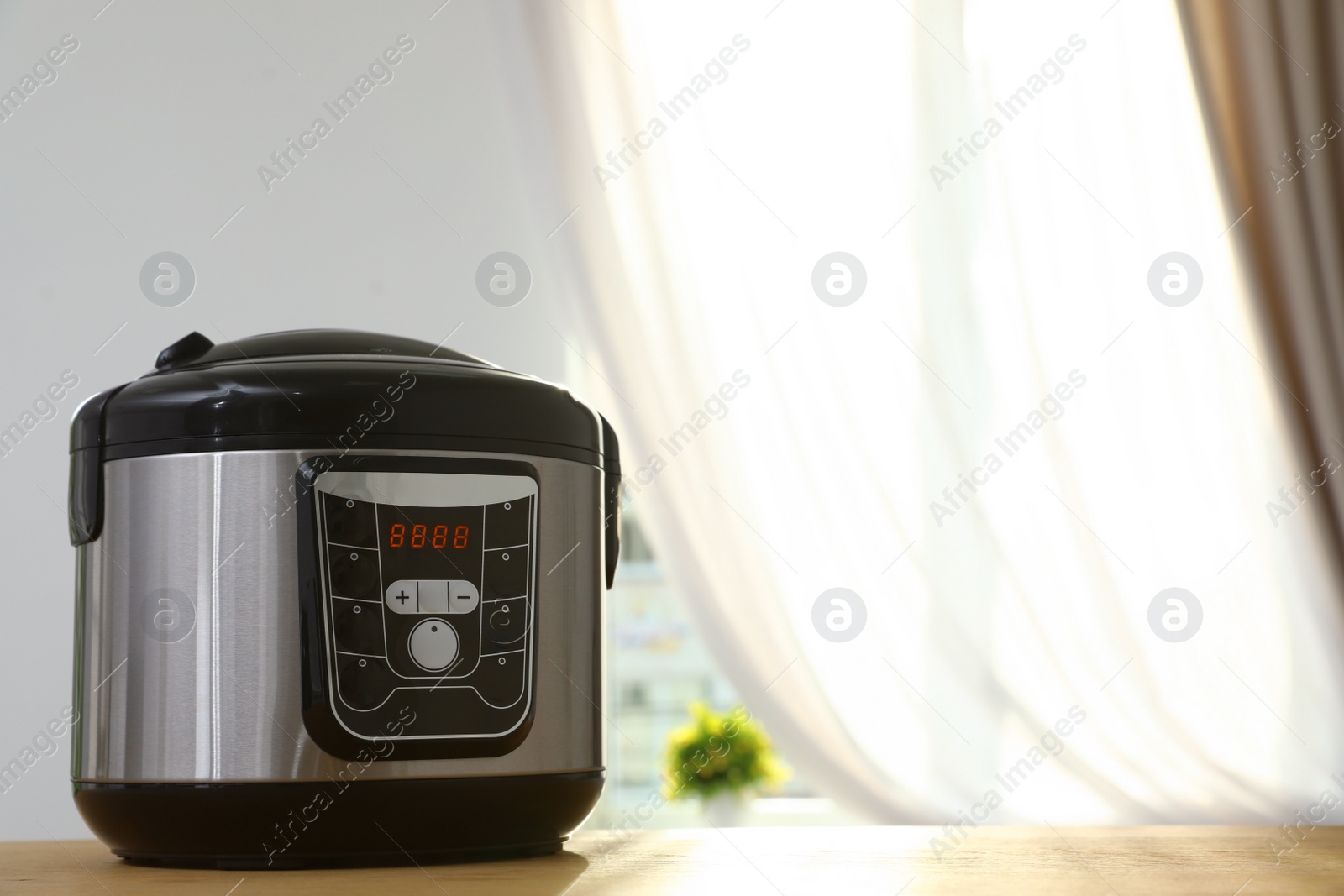 Photo of New modern multi cooker on table indoors. Space for text