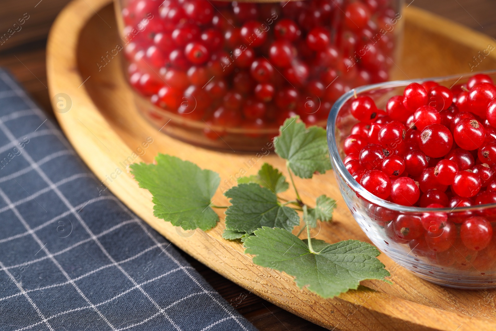 Photo of Ripe red currants and leaves on table, closeup