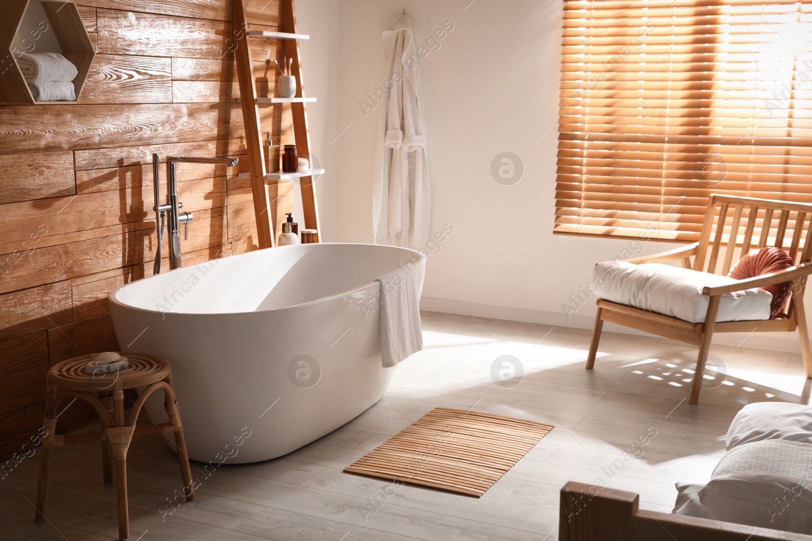 Photo of White tub and decor near wooden wall in room. Interior design