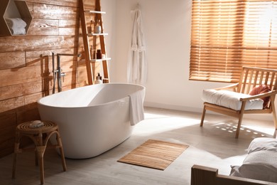 White tub and decor near wooden wall in room. Interior design