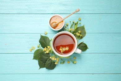 Photo of Flat lay composition with tea and linden blossom on light blue wooden table