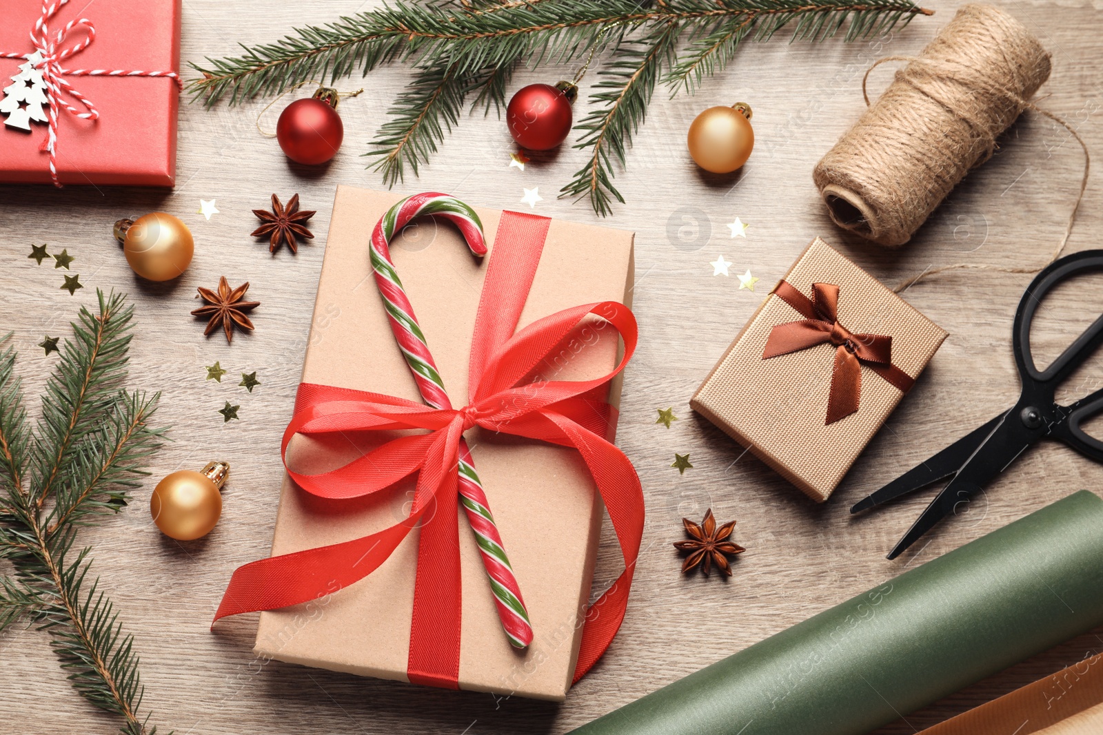 Photo of Flat lay composition with beautiful Christmas gift boxes and wrapping paper on wooden table