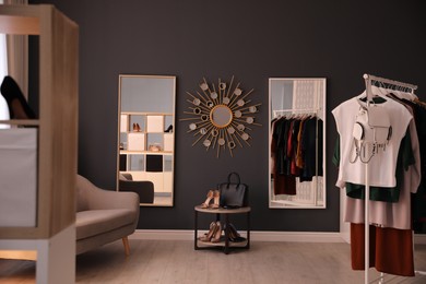 Photo of Stylish women's clothes and accessories in modern boutique