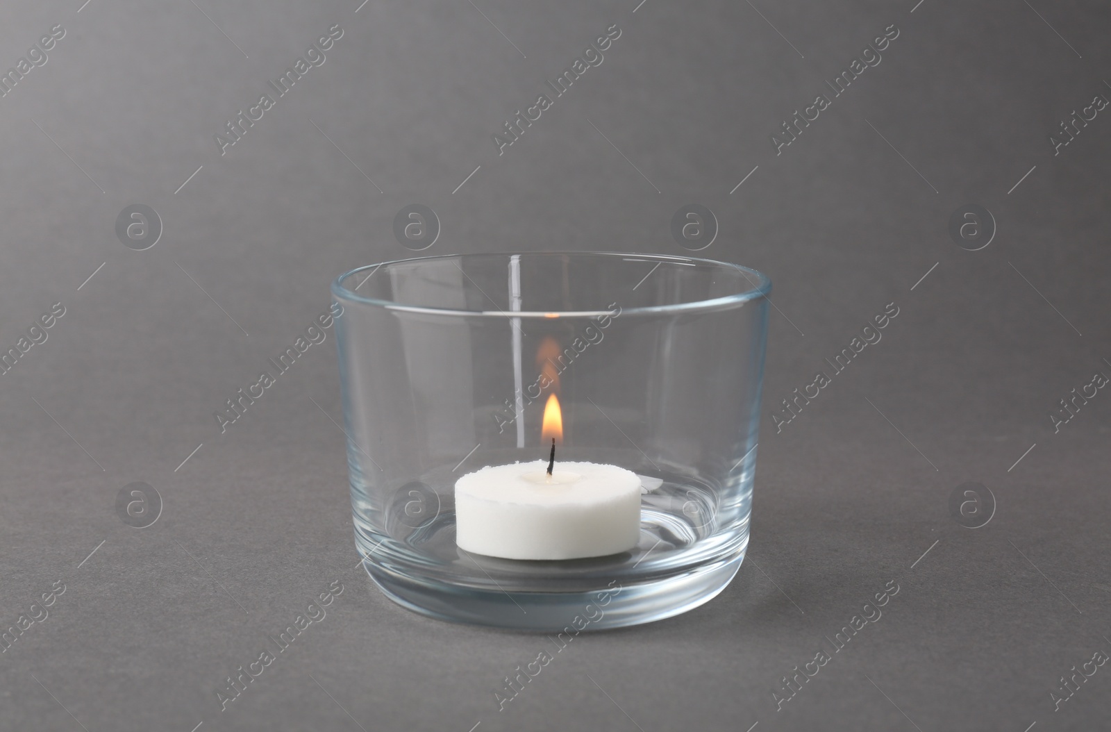 Photo of Candle in glass holder on grey background