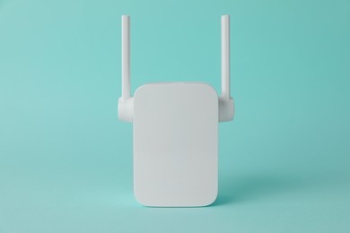 Photo of New modern Wi-Fi repeater on turquoise background