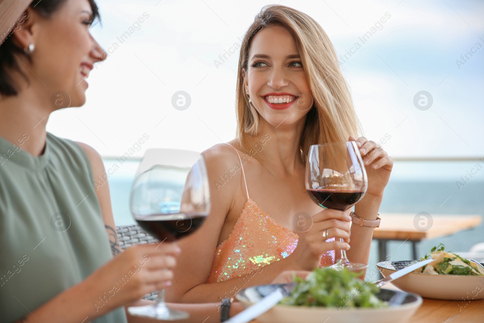 Photo of Young women with glasses of wine at table