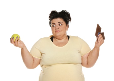 Photo of Emotional overweight woman with apple and chocolate on white background