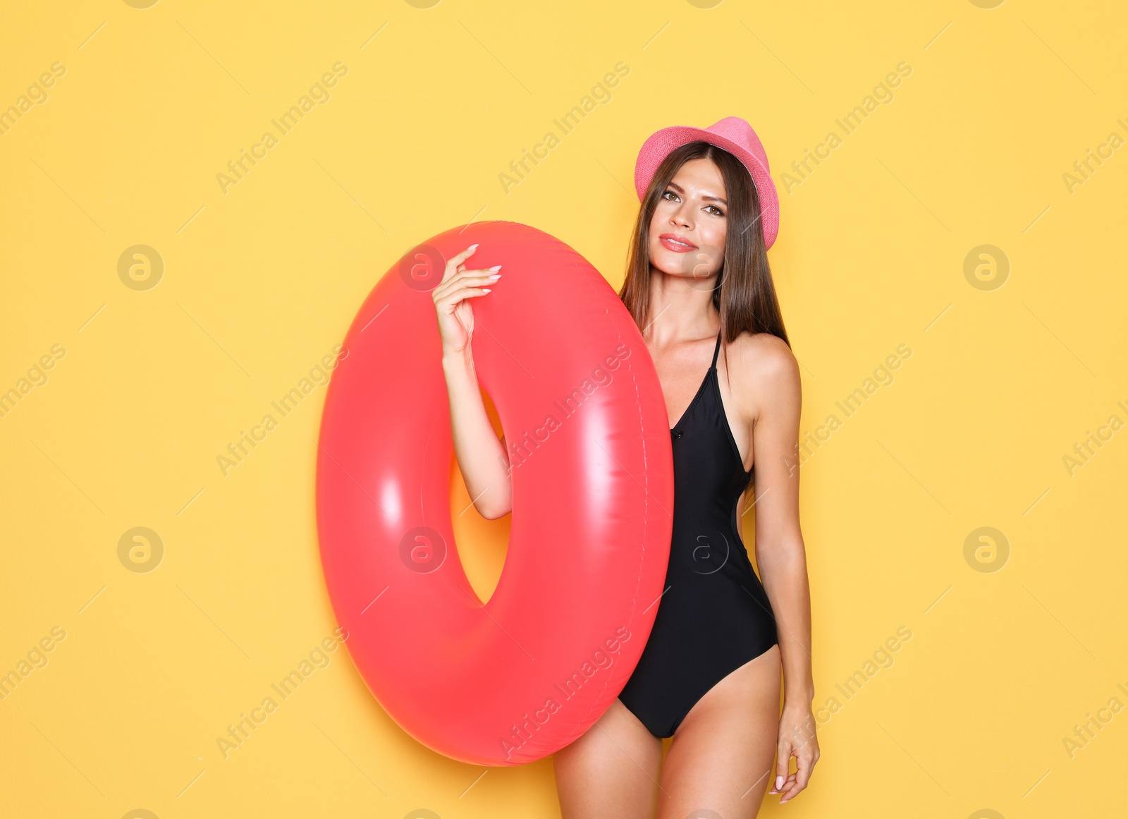 Photo of Sexy young woman in bikini with inflatable ring on color background