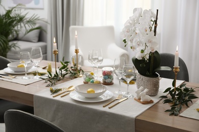 Photo of Beautiful Easter table setting with white orchid flowers indoors