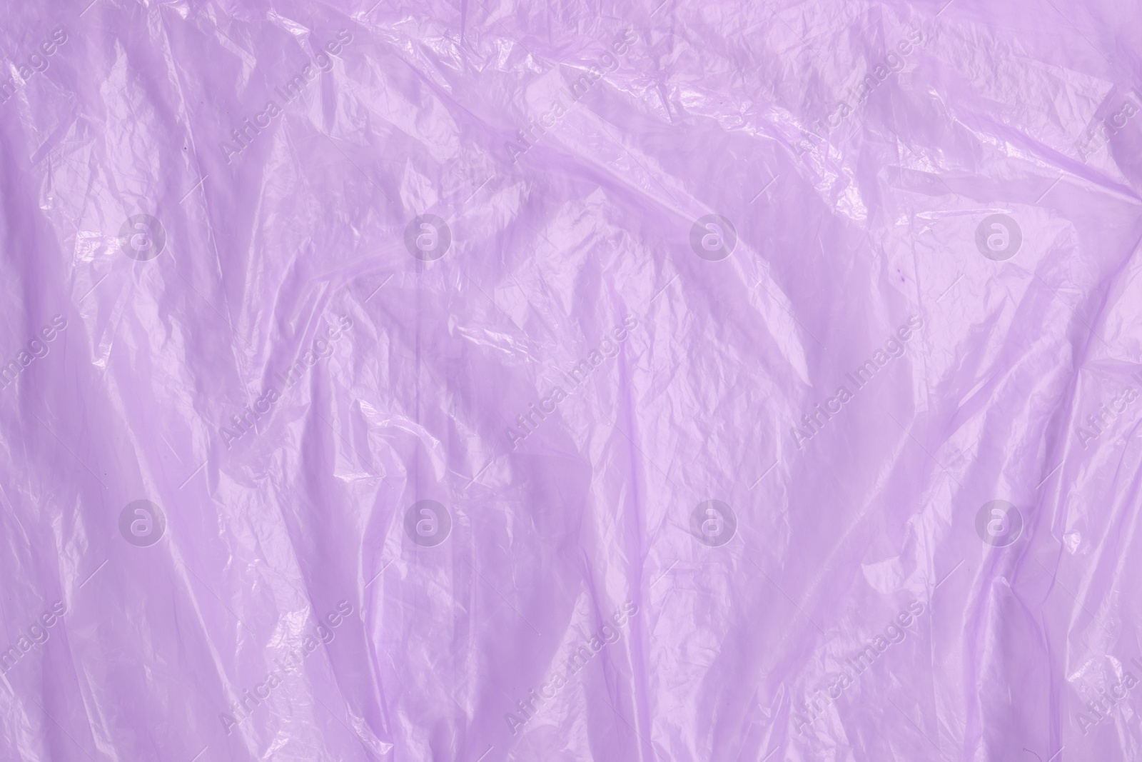 Photo of Crumpled purple plastic bag as background, top view