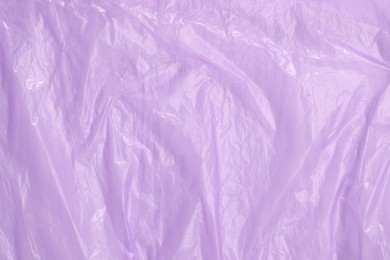 Crumpled purple plastic bag as background, top view