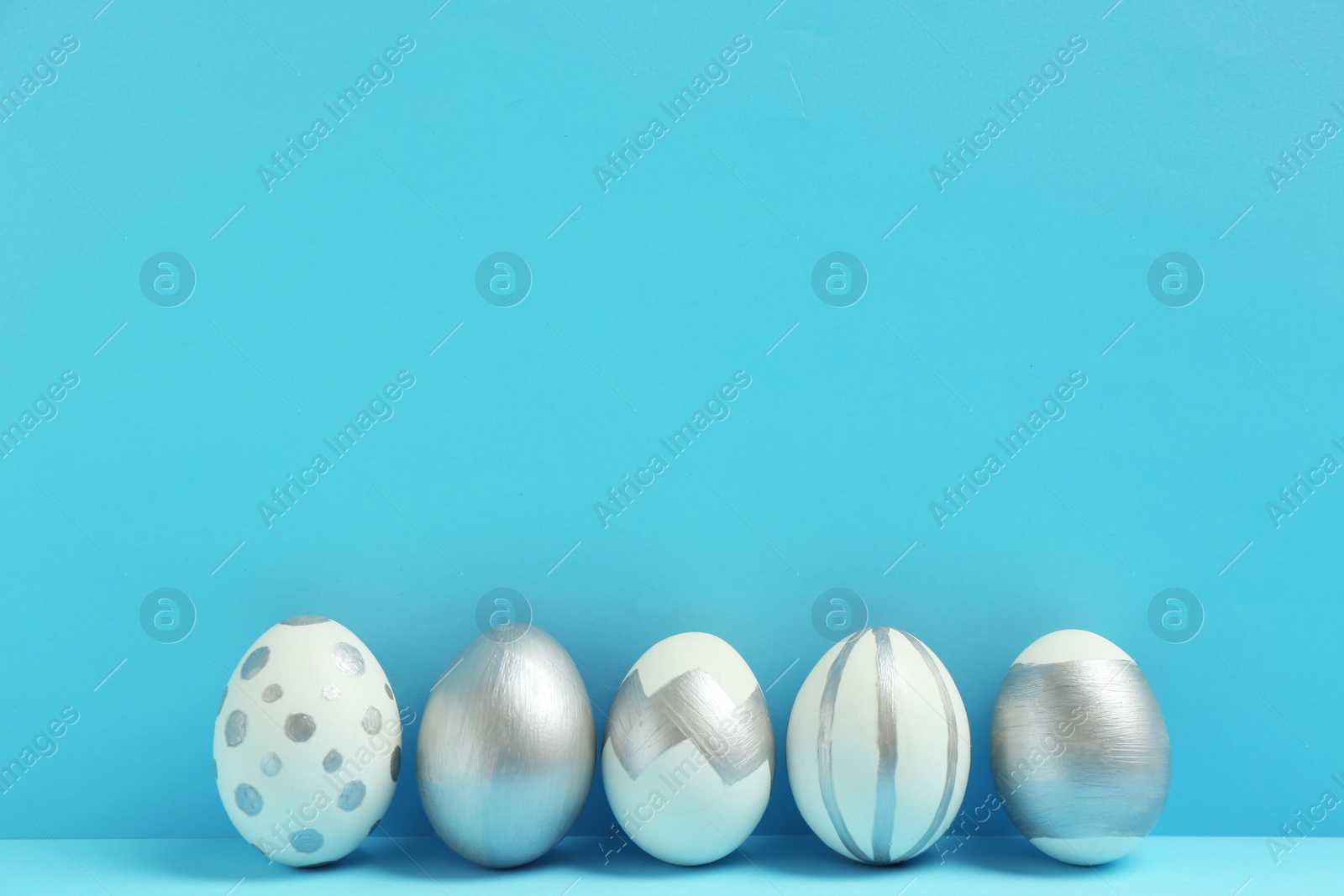 Photo of Painted Easter eggs on color background, space for text. Stylish design