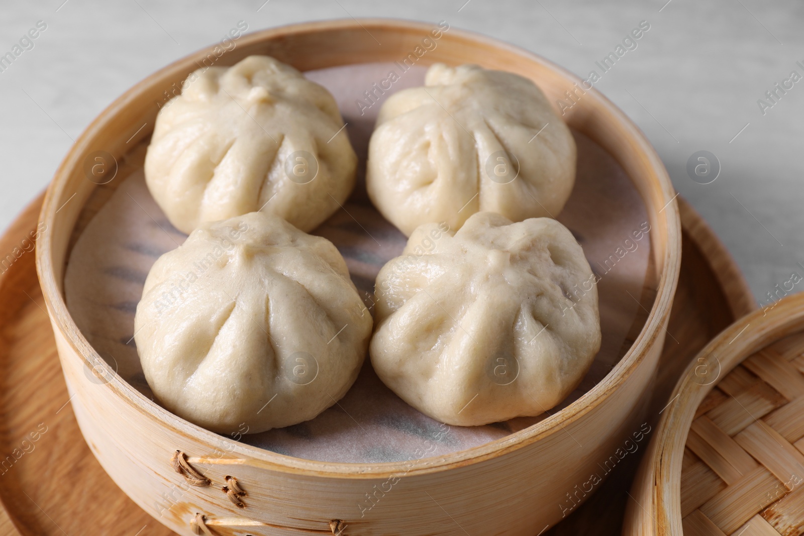 Photo of Delicious bao buns (baozi) on light table, closeup