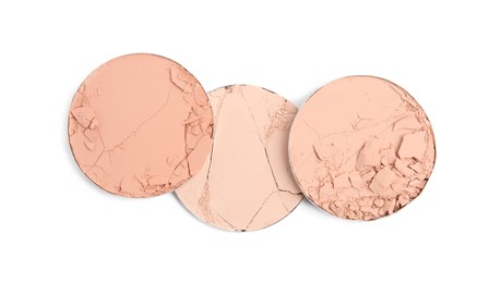 Photo of Different broken face powders on white background, top view