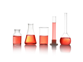 Photo of Different laboratory glassware with red liquid isolated on white