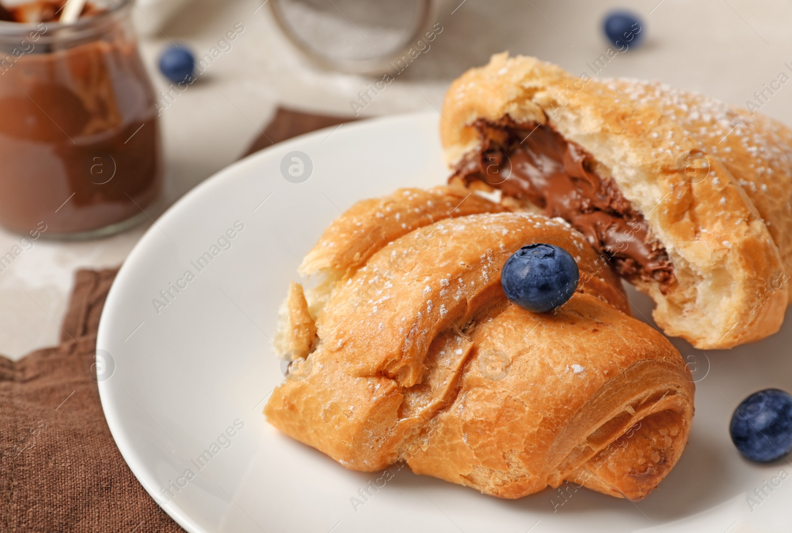 Photo of Tasty croissant with chocolate on plate, closeup