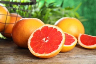 Photo of Fresh tasty grapefruits on table against blurred background