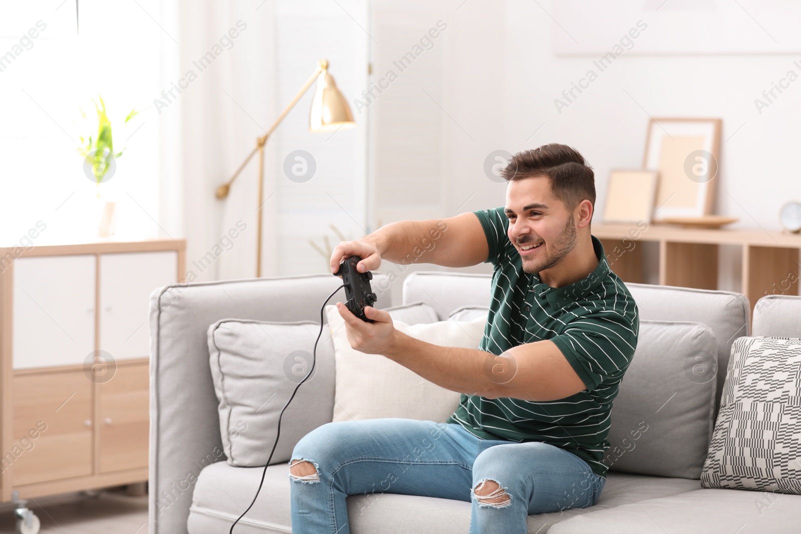 Photo of Emotional young man playing video games at home