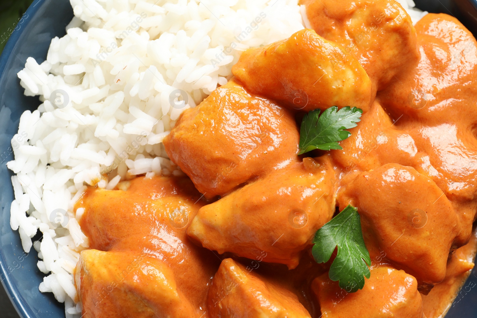 Photo of Butter chicken with rice in bowl, closeup. Traditional indian Murgh Makhani