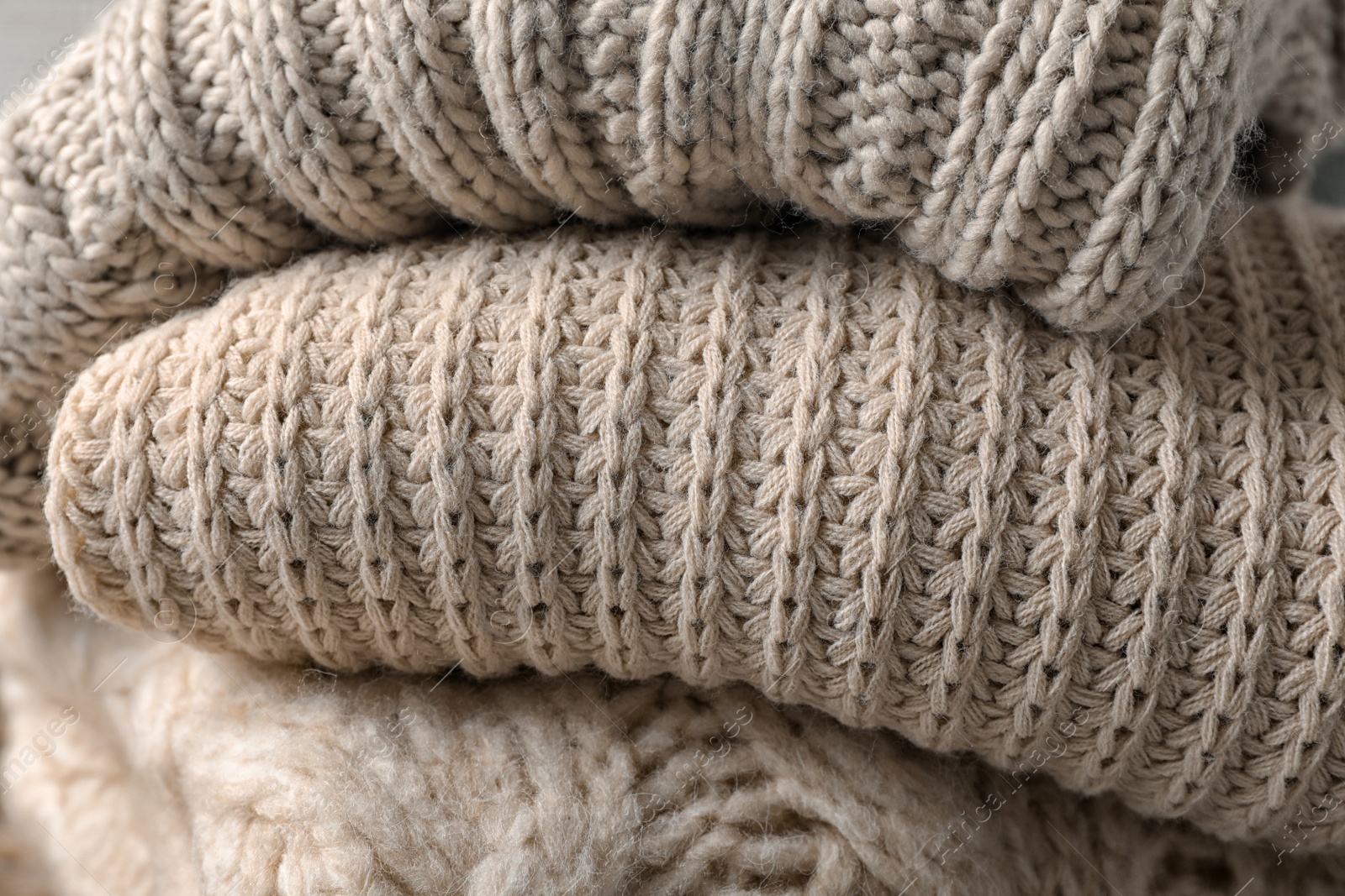 Photo of Stack of folded warm knitted sweaters, closeup