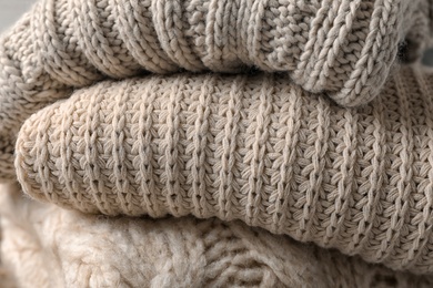 Photo of Stack of folded warm knitted sweaters, closeup