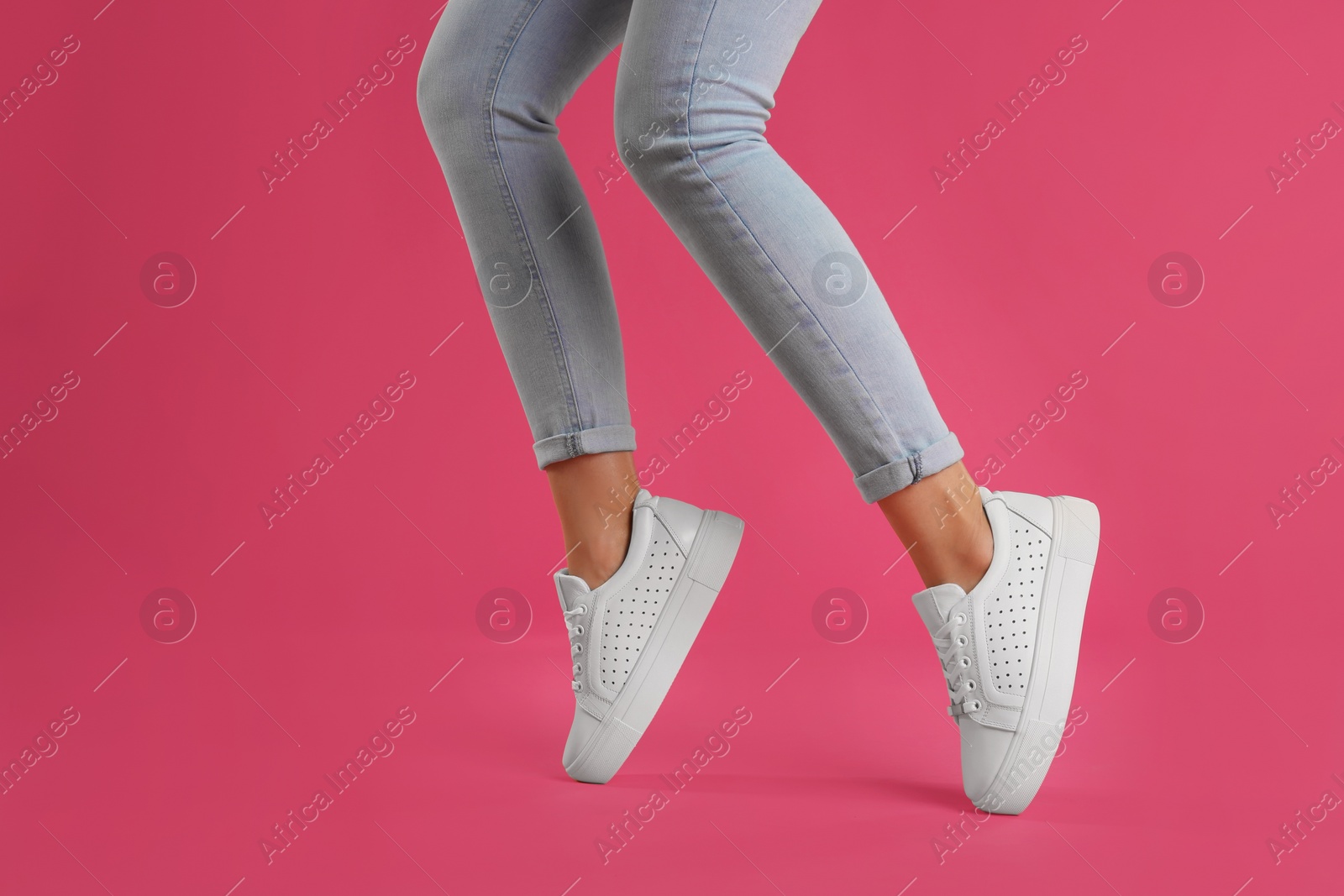 Photo of Woman wearing shoes on pink background, closeup