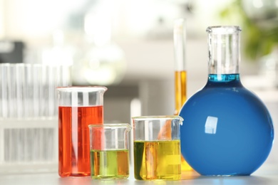 Photo of Glassware with color liquids on table in laboratory