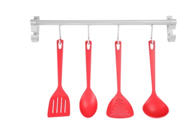 Metal rack with set of red kitchen utensils on white background