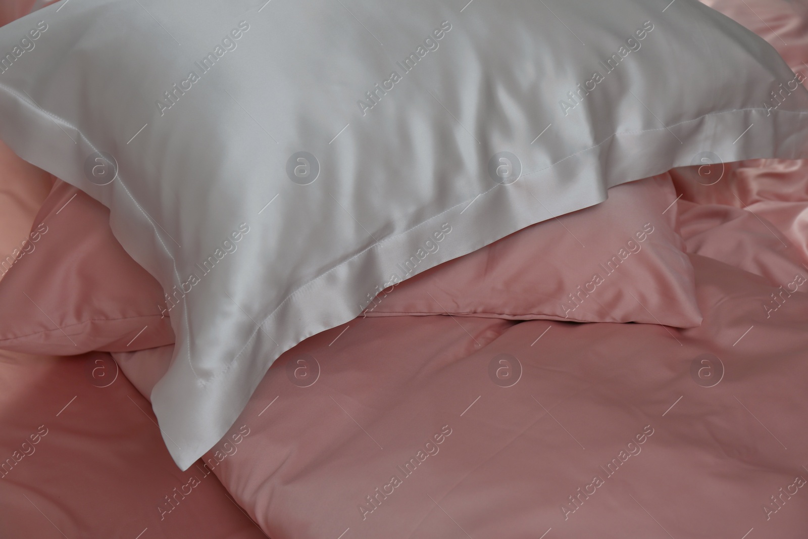 Photo of Closeup view of bed with beautiful silk linens