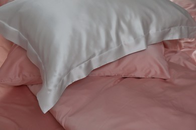 Photo of Closeup view of bed with beautiful silk linens