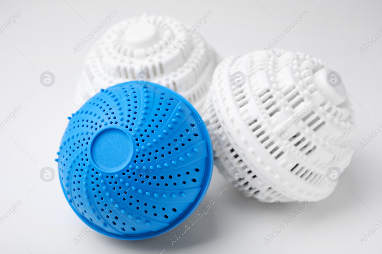 Photo of Dryer balls for washing machine on white table, closeup. Laundry detergent substitute