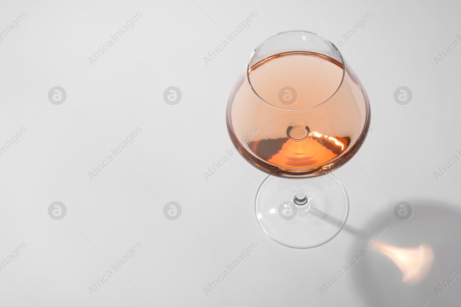 Photo of Tasty rose wine in glass isolated on white