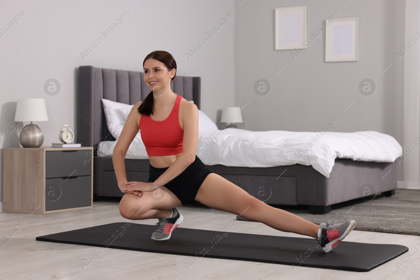 Photo of Morning routine. Happy woman doing stretching exercise at home, space for text